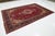 This Persian Tabriz Hand-knotted wool rug has a red field with multicolor accents featuring an allover floral design. This...