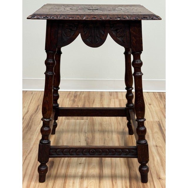 Antique English carved oak joint side table with splayed legs. Features intricately carved beveled edge top above the...
