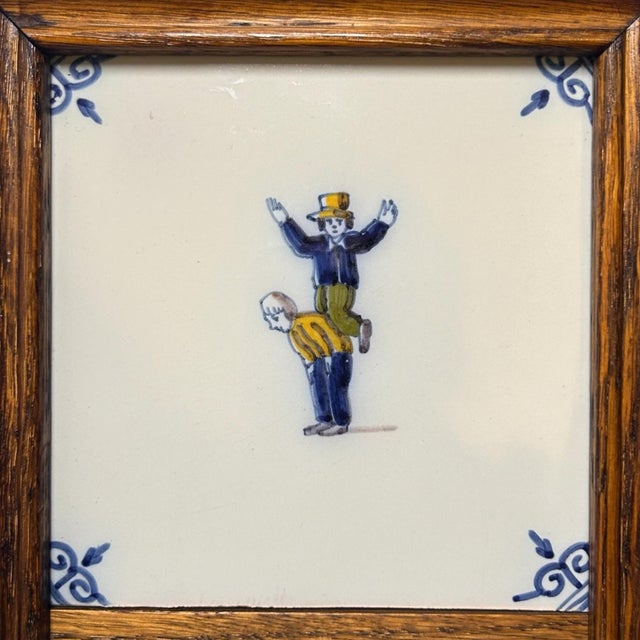 A charming mid-20th-century framed tile panel by Tichelaar Makkum, composed of three hand-painted Dutch ceramic tiles...