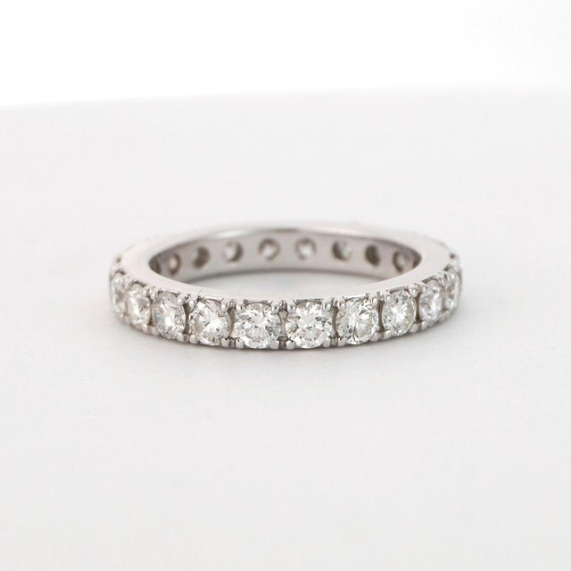 2020 This elegant ring is crafted in 18k white gold. It features a continuous row of round white diamonds, each with a G...