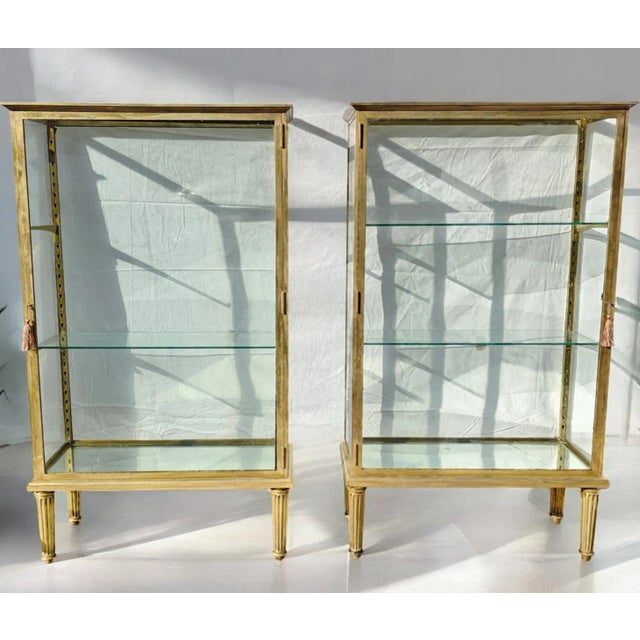 This Exquisite and Parisian Chic pair of double-sided brass and glass display cabinets beautifully fuse sophistication and...