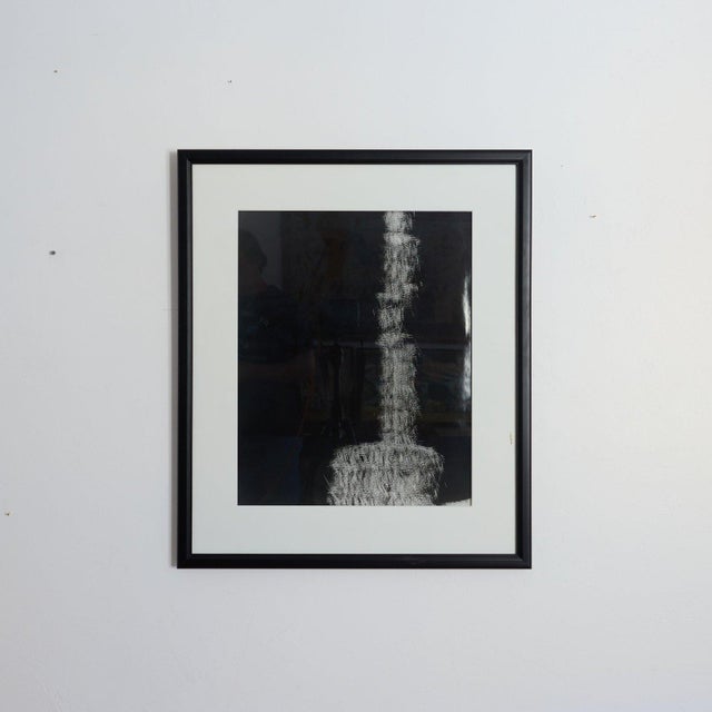 Vintage abstract monochrome work in deep black and gray tones, presented in a black wood frame with a wide white mat.