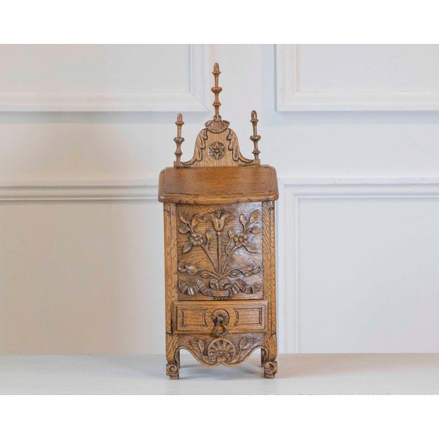 A finely crafted French flour box dating from the early 20th century, showcasing the skill of a cabinetmaker-sculptor and...