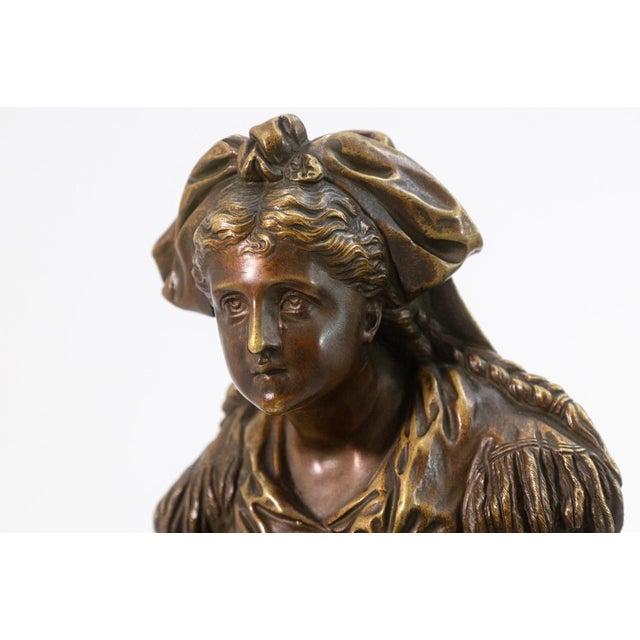 This finely cast bronze sculpture by French artist Pierre Louis Detrier depicts a woman carrying a child, rendered with...