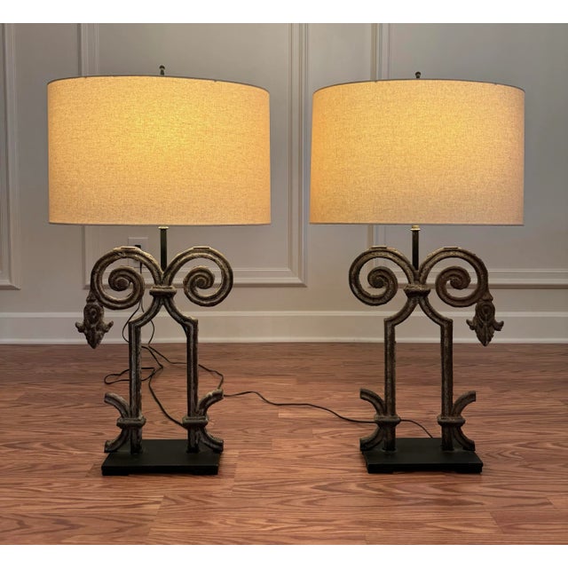 This pair of cast iron architectural relic lamps have a rustic farmhouse, French country aesthetic.. The wrought iron base...