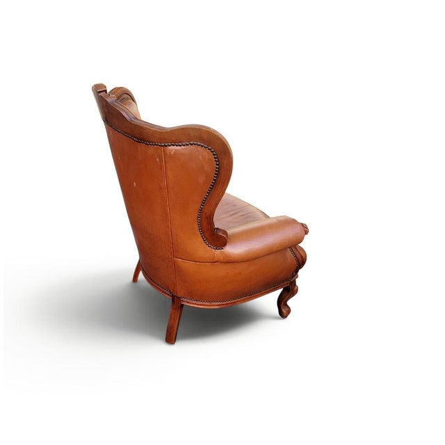Exceptional antique Chesterfield wing chair dating to approximately 1910, featuring high-quality cognac brown leather,...