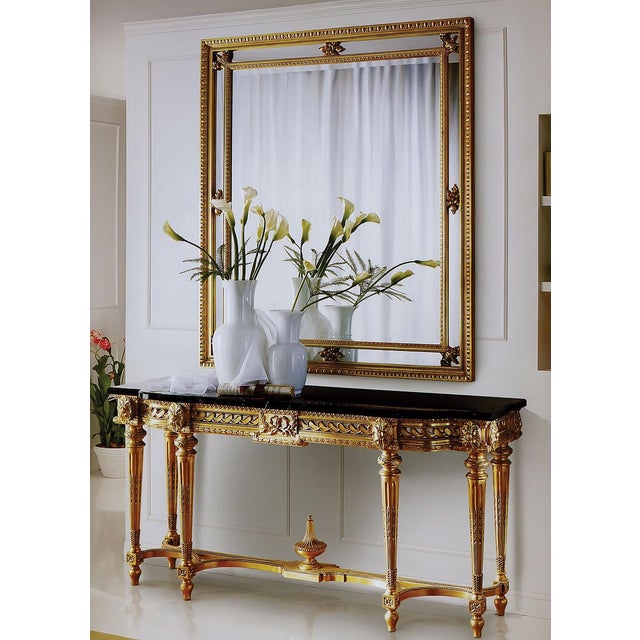 Handcrafted in Italy and richly hand carved in the neoclassical tradition, this piece is finished in 24karat antique gold...