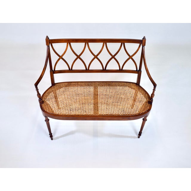 A refined Mahogany Sheraton style caned settee with interlacing lattice back, turned tapered arms and legs. New custom...