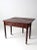 Elegant 19th-century writing desk in warm wood with two drawers, turned legs, and casters. The rear drop leaf opens to...