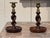 A pair of oak barley twist candlesticks with brass sconces and turned dished bases.