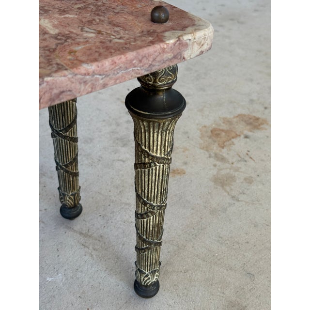 Elegant neoclassical-style table featuring a softly veined pink marble top supported by finely detailed gilt metal legs....