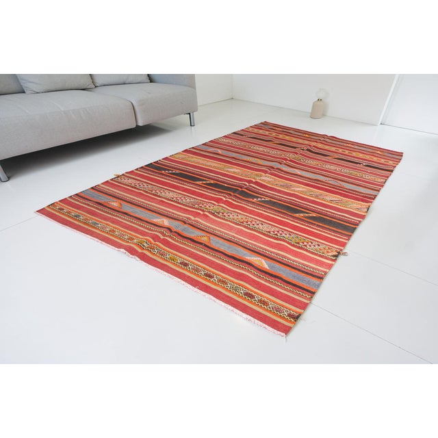This is a vintage Turkish Oushak rug from the Mid 20th Century. The piece was hand-knotted.