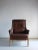 Vintage brown leather lounge chair with curved details. Dimensions: H 100 cm, H(seat) 42 cm, W(back/seat) 80/60 cm,...