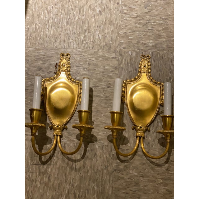 A pair of circa 1920’s gilt bronze neoclassic style sconces with 2 lights, original gilding