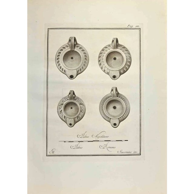 Pompeian Style Oil Lamps from "Antiquities of Herculaneum" is an etching on paper realized by Marcantonio Iacomino in the...