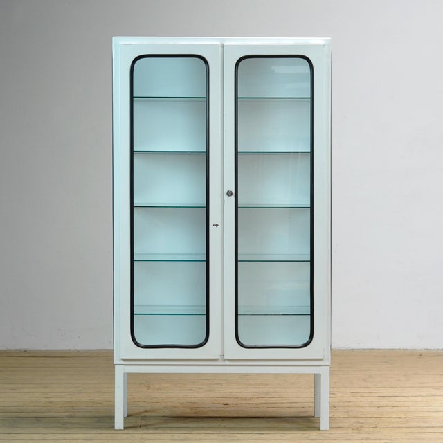 Vintage medical cabinet from the 1970s, made in Hungary. This characterful cabinet is made of iron and glass, with the...