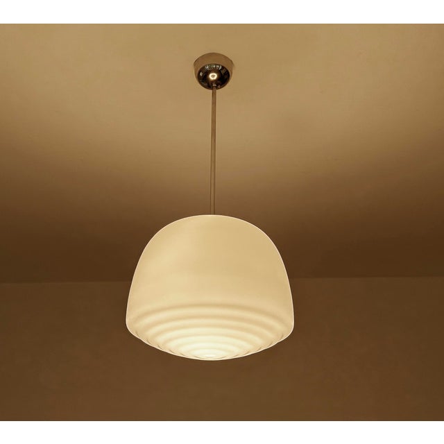 Bauhaus / art deco pendant light, featuring a pear shaped opaline glass shade with a ripple bottom pattern mounted on a...