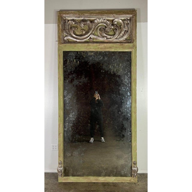 Grand Italian Baroque style trumeau mirror with a painted frame in a gentle shade of green, suggesting an air of...