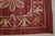 An 8' x 11' hand-knotted wool rug with a red field with an ivory lattice of flowers and birds, in a low, dense Afghan wool...
