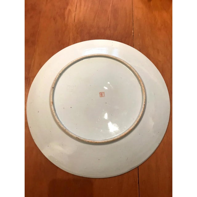 An Japanese porcelain plate circa 1930s-1940s. Decorated with over glaze featuring three ladies in waiting. In the garden,...