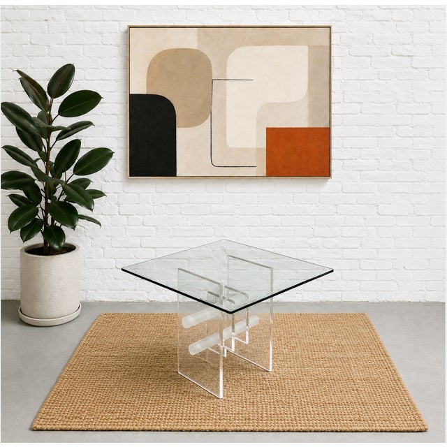 A striking sculptural coffee or side table featuring a thick square glass top resting on an architectural Lucite base....