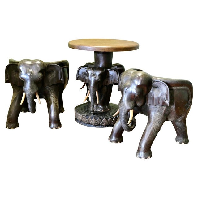 A Very Unusual Set of Elephant Chairs and Table A very unusual mid 20th century Anglo Indian vintage hand carved lounge...