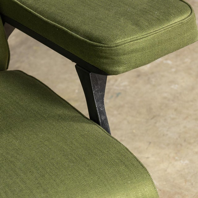 A pair of mid 20th century italian lounge chairs, designed by roberto menghi, featuring sleek black metal frames paired...