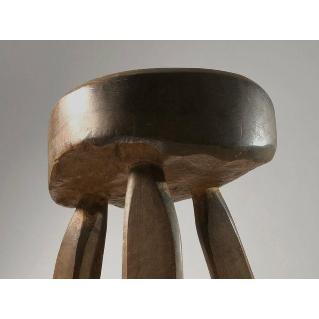 A magnificent and sculptural tripod stool, Modernist, Brutalist, Popular Art, in solid gouge-cut wood, to be attributed,...
