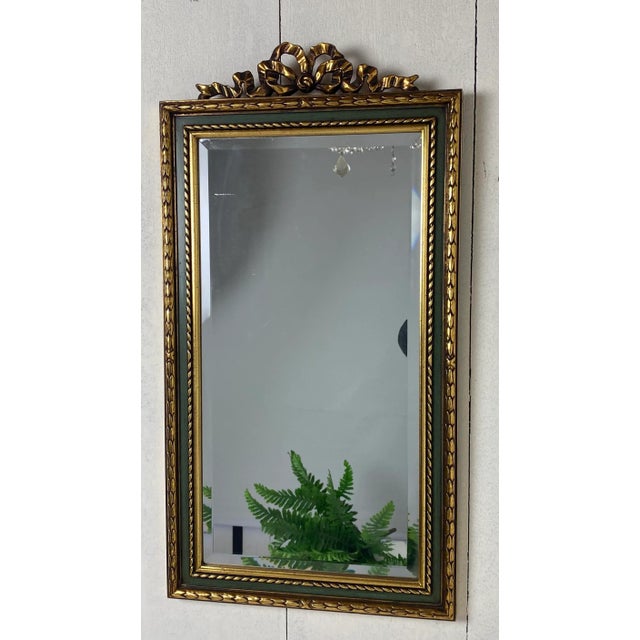 Beautiful original DeKnudt mirror. In a vintage-antique version with gold and green and a Louis Seize bow. The authentic...