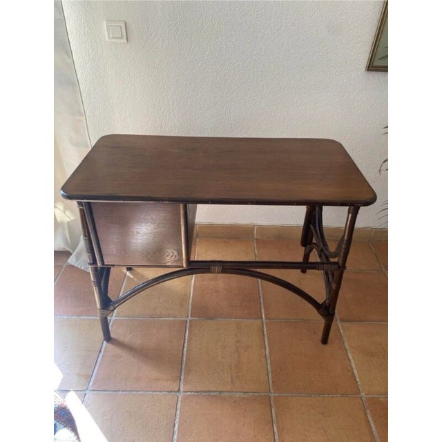 Vintage rattan and dark brown wood desk from the 1950s-1960s. Curved arches on the sides and a curved crossbar under the...