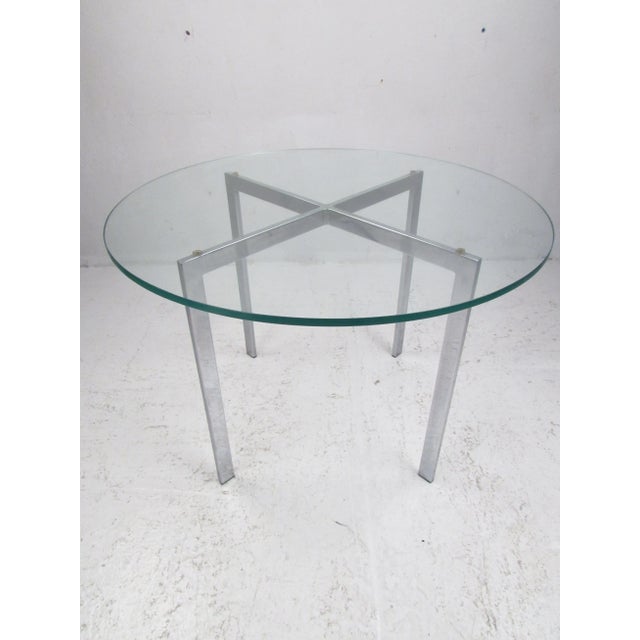 Sleek and modern round top glass coffee table. Featuring a 1/2" beveled glass top and a X shaped chrome metal base.