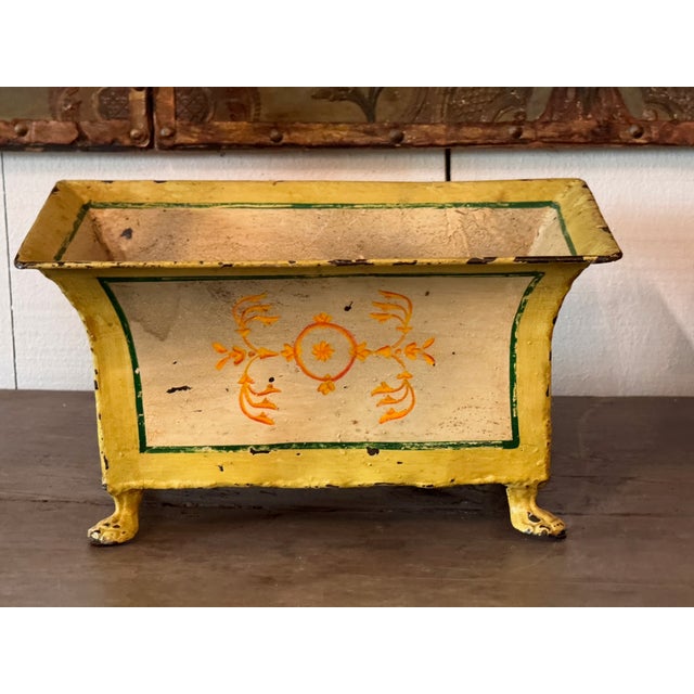Pair of French tole cachepots of rectangular flared form, painted in yellow with green line borders framing pale panels...