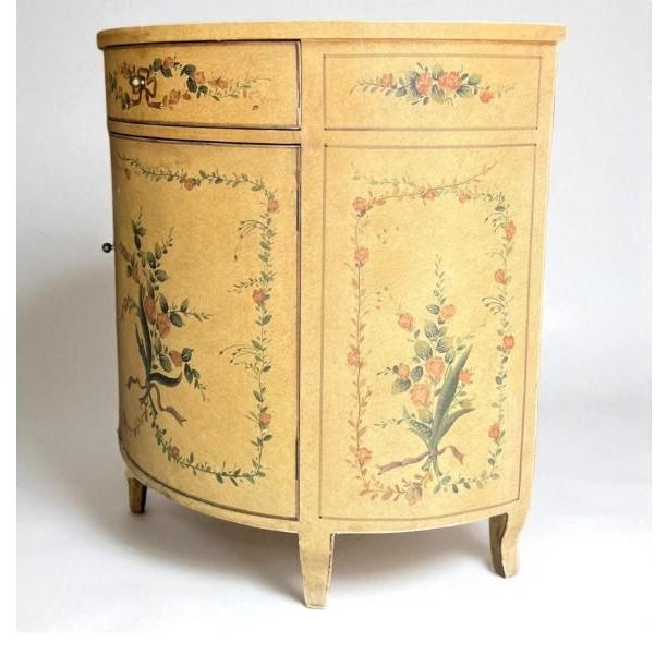 Charming half-moon demilune cabinet with hand-painted floral details. This piece features a curved front design with one...