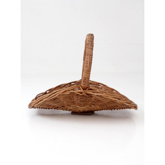 This vintage wicker hearth basket features a beautifully open handwoven form with a wrapped bentwood handle and a warm...