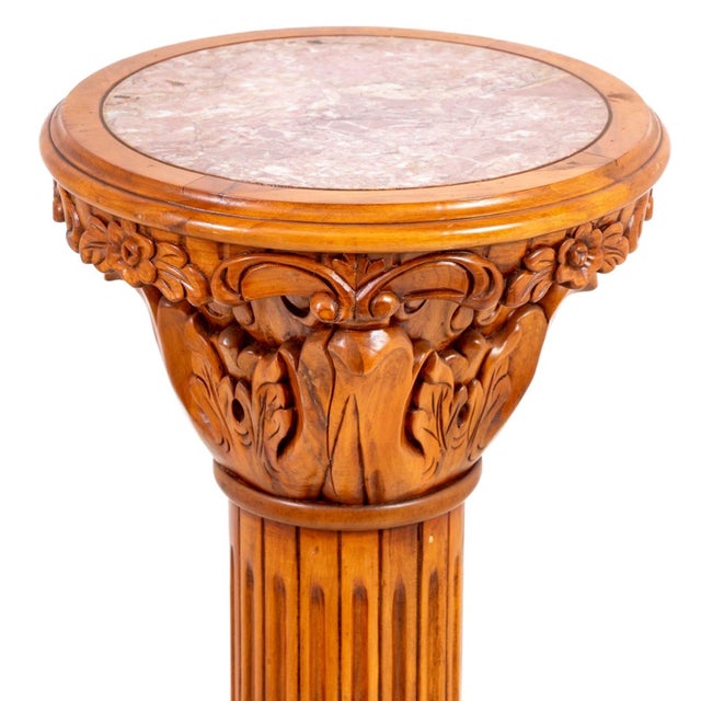 Neoclassical Pine and Marble Pedestal, 20th century, the circular top inset with pink marble above a carved capital fluted...
