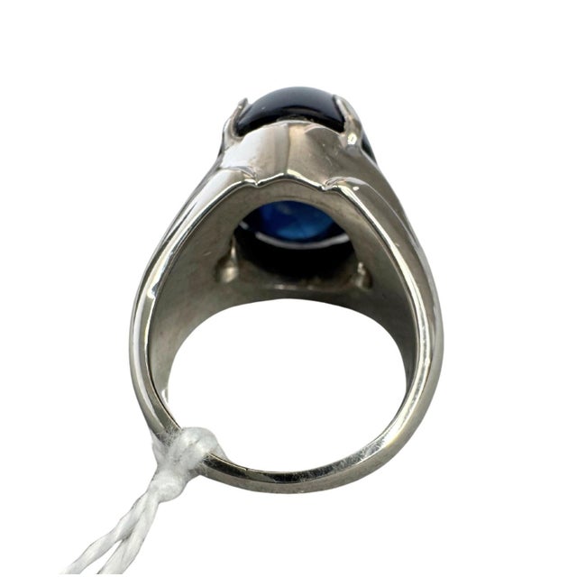 Centering a 21.57 carat natural Thai blue sapphire, this impressive cocktail ring features a luminous oval cabochon. The...