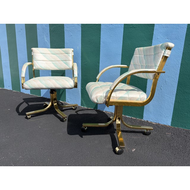 A Pair of Early 1990s Post Modern Brass Rolling Dining Chairs by Cal-Style Furniture. Features Brass Frames with the...