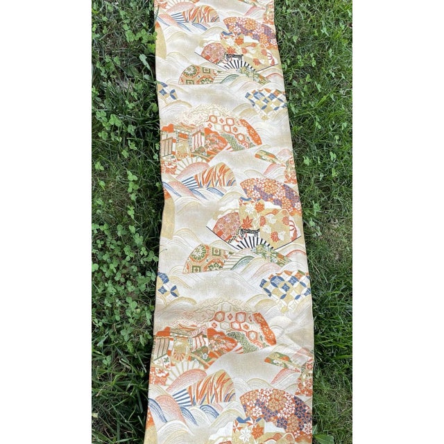 A beautiful mid-20th-century vintage Japanese silk brocade Fukuro obi sash. The textile features intricately woven...