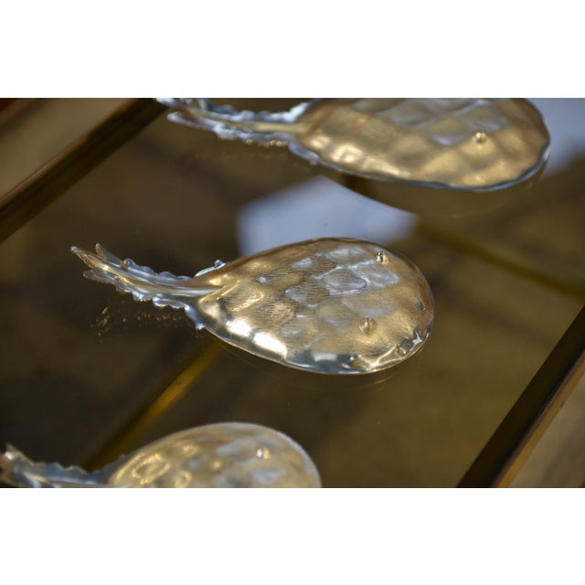 Three nesting pineapple-shaped bowls, made of metal with a grid pattern and stylized leaf handles. A symbol of hospitality...