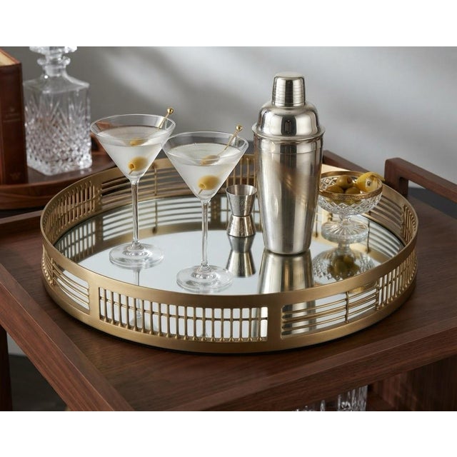 Elevate your surface styling with this striking, heavy-weight round mirrored tray. Featuring a gleaming gold-toned finish...