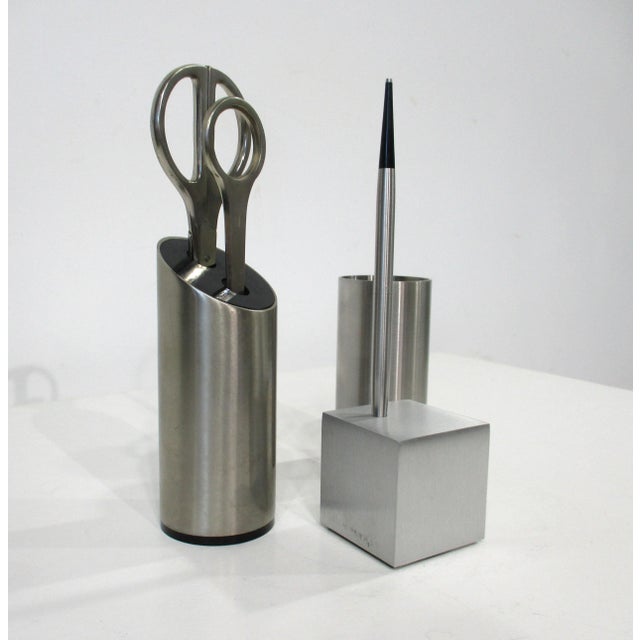 A three piece stainless Aluminum desk set with scissors , letter opener , holder , pen , holder and open tube for other...