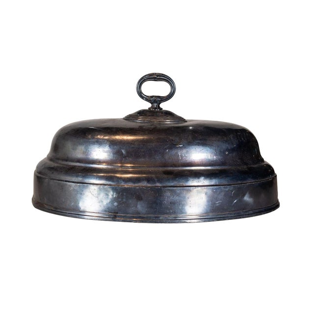 Silver plated serving cloche with sculpted handle.