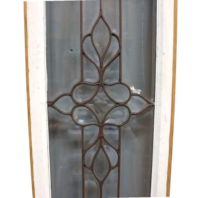 This antique architectural window, dating to approximately 1910, features a leaded glass design with a central floral...