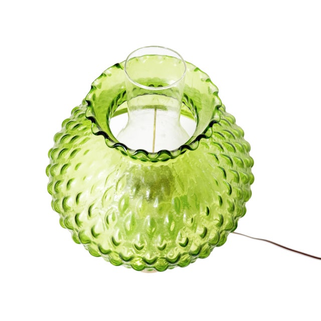 A striking vintage electric hurricane table lamp featuring richly textured emerald-green glass, a sculptural diamond-...