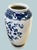 A striking vintage Japanese porcelain vase featuring a beautifully rendered peacock surrounded by lush florals, all...