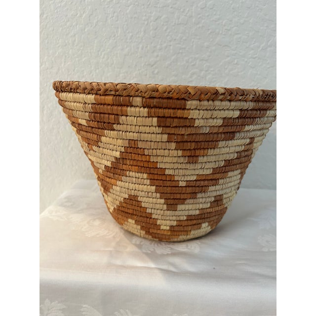 Generous size, vintage, artisan African woven coiled straw basket in shades of cream and dark tan.
