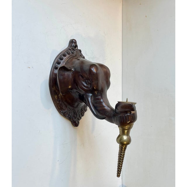 A pair of elephant candle sconces in cast bronze. Regency style with a hint of colonial fauna. Each elephant head has a...