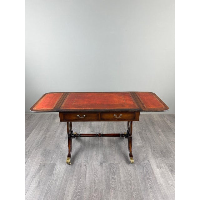 An elegant Empire-style mahogany games table, dating from the late 19th or early 20th century. It features a beautiful...