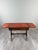 An elegant Empire-style mahogany games table, dating from the late 19th or early 20th century. It features a beautiful...