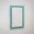Rectangular wall mirror with a light blue transparent glass frame featuring a faceted inner edge. The piece exemplifies...